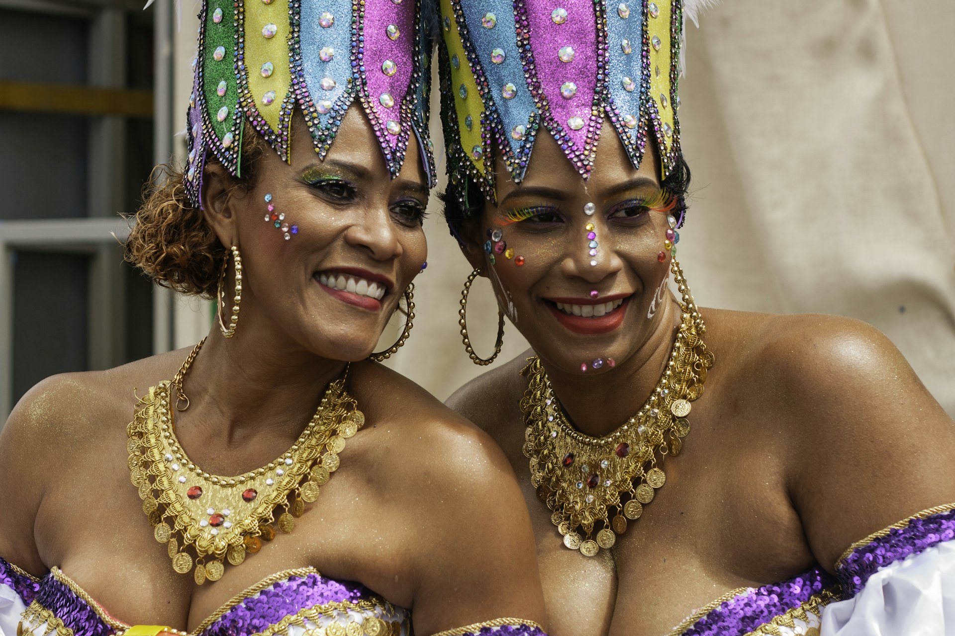 Colorfully dressed women smiling during the Carnival parade in Curaçao