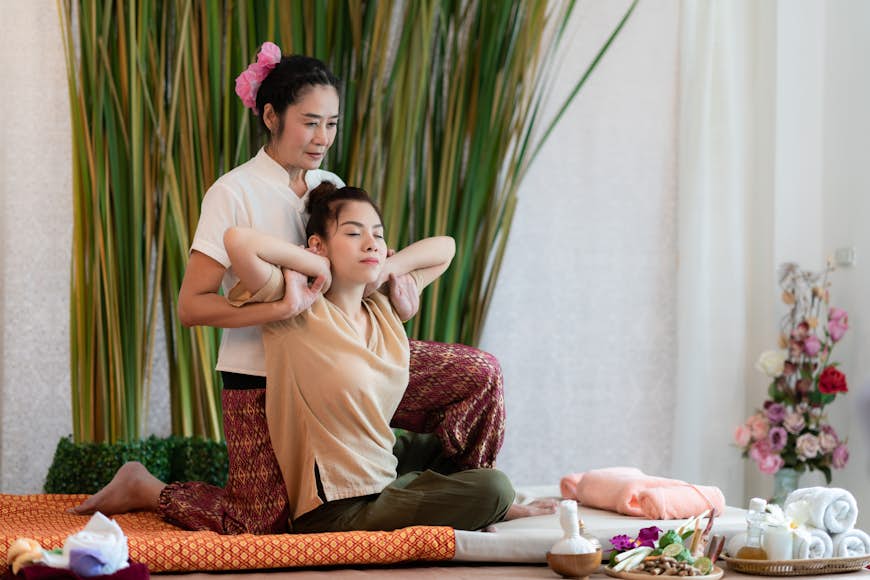 A woman receiving a Thai massage at a spa for healing and relaxation