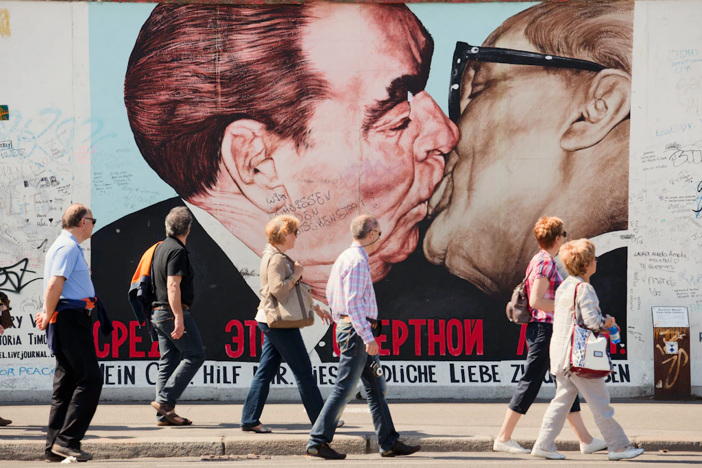 'My God, Help Me to Survive This Deadly Love' artwork, East Side Gallery People walk past the 'My God, Help Me to Survive This Deadly Love' artwork on the East Side Gallery in Berlin. The artwork depicts a Russian and East German politician kissing.