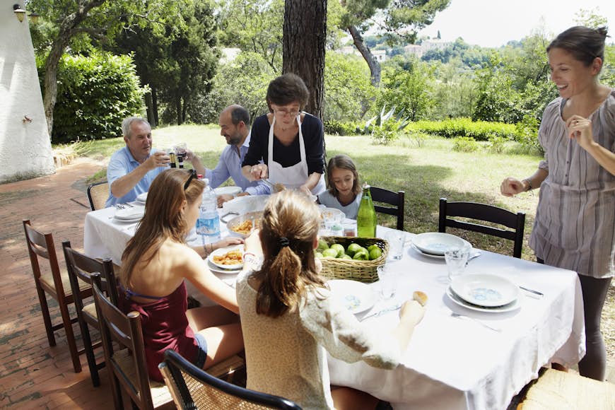 Семья ест вместе за столом на открытом воздухе