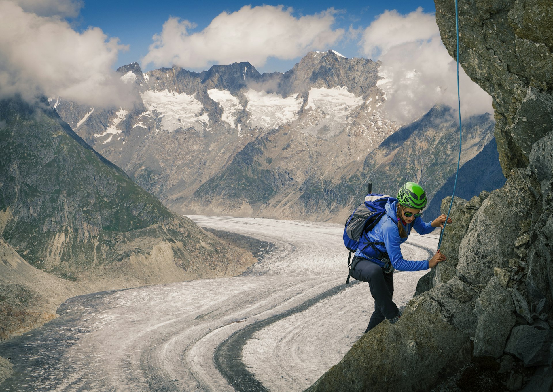 Climber on rock face over Aletsch Glacier in Switzerland