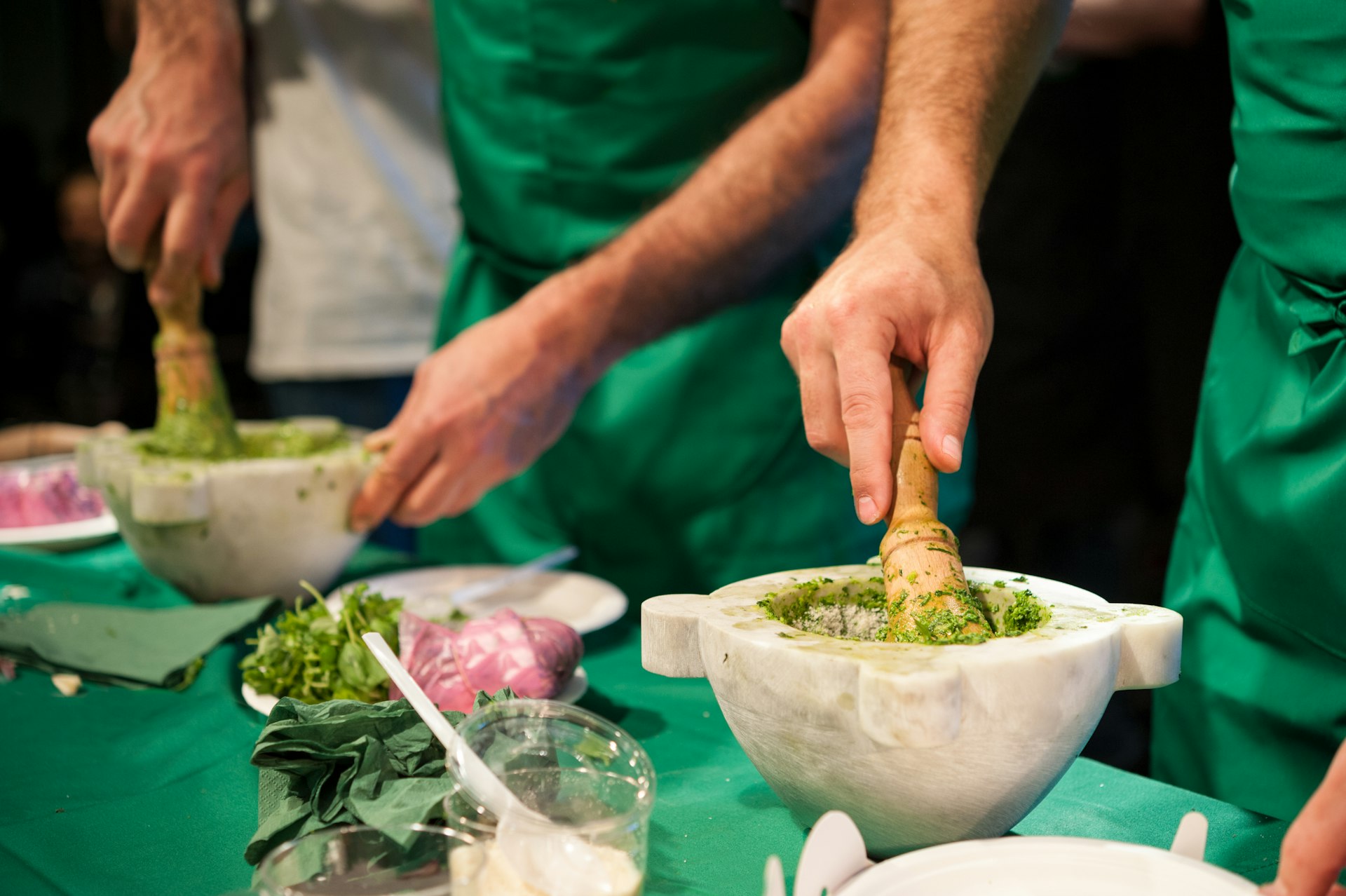 People working in a kitchen preparing Pesto basil sauce