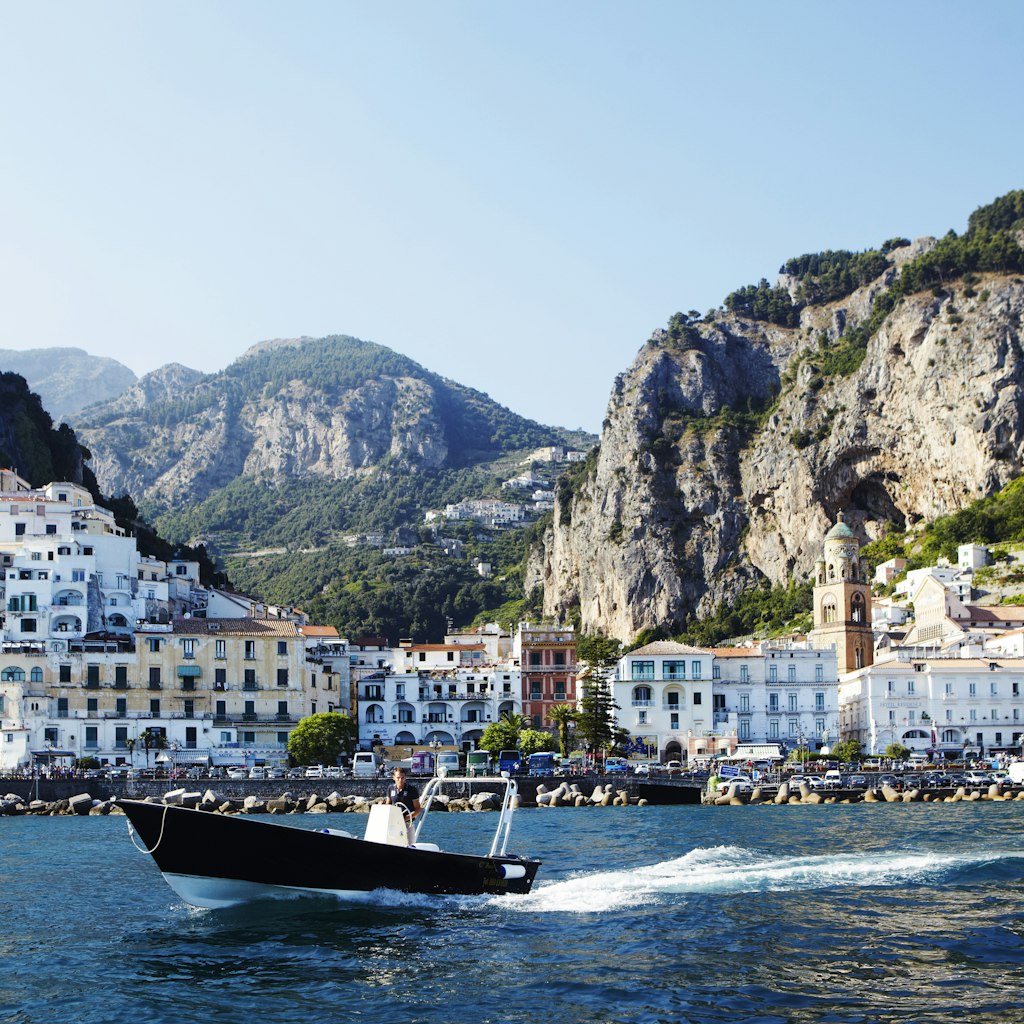 Passing boat on Tyrrhenian sea with Amalfi town in background.