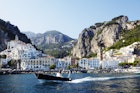Passing boat on Tyrrhenian sea with Amalfi town in background.