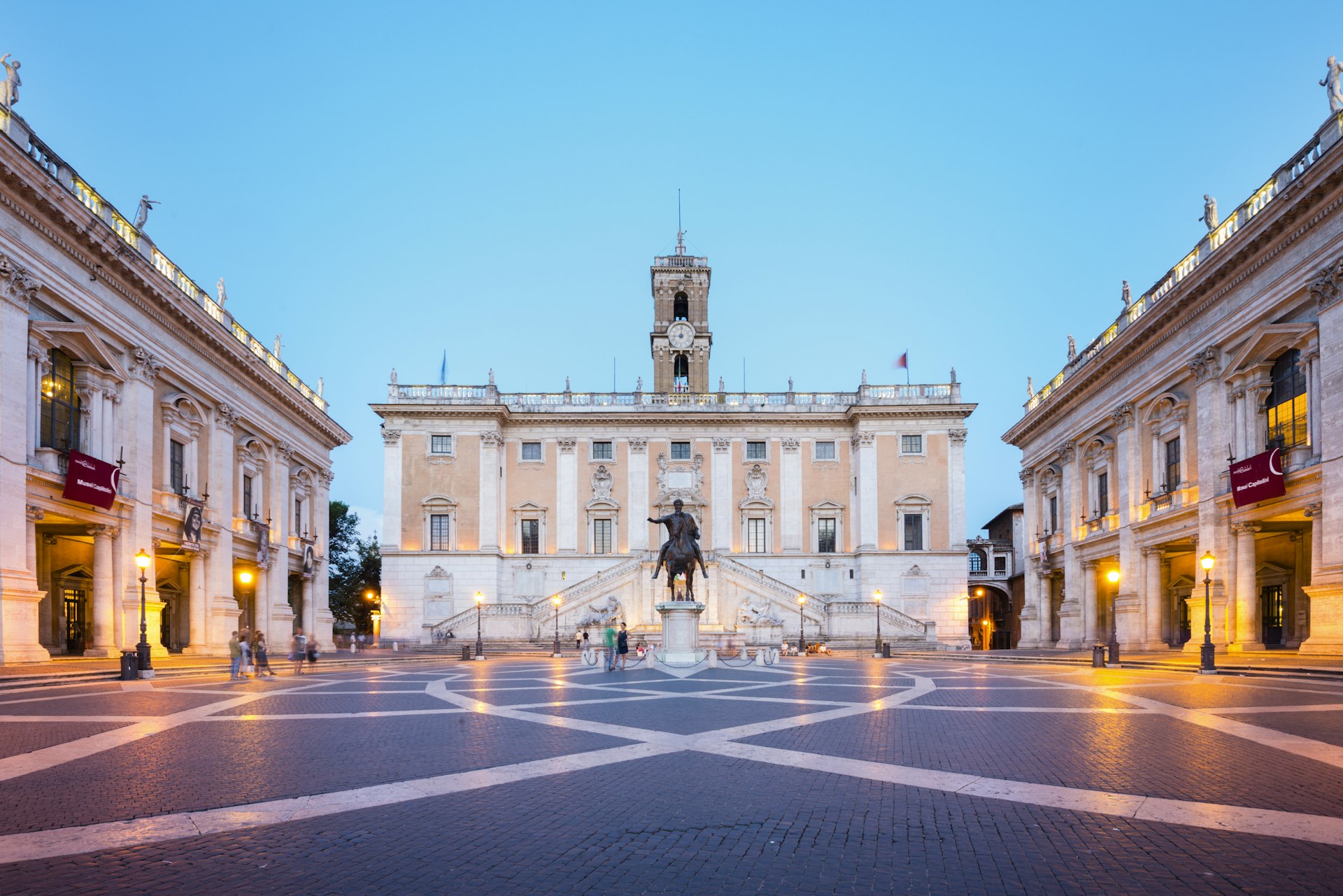 An empty square lined with classical buildings at dusk