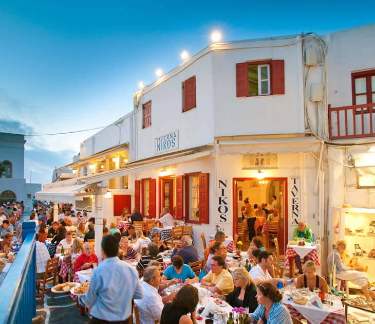 Tourists dining al fresco at Taverna Nikos, in Mykonos, Greece for evening meal.