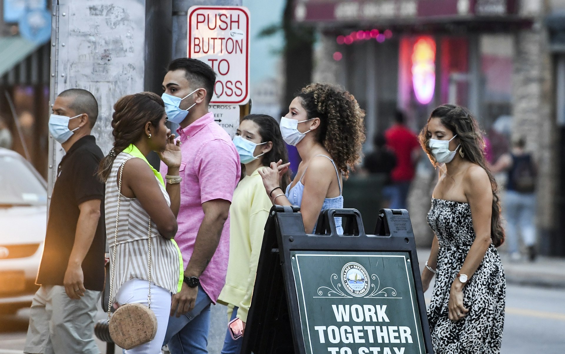 Young people wear masks while walking on Main Street in Patchogue on Long Island