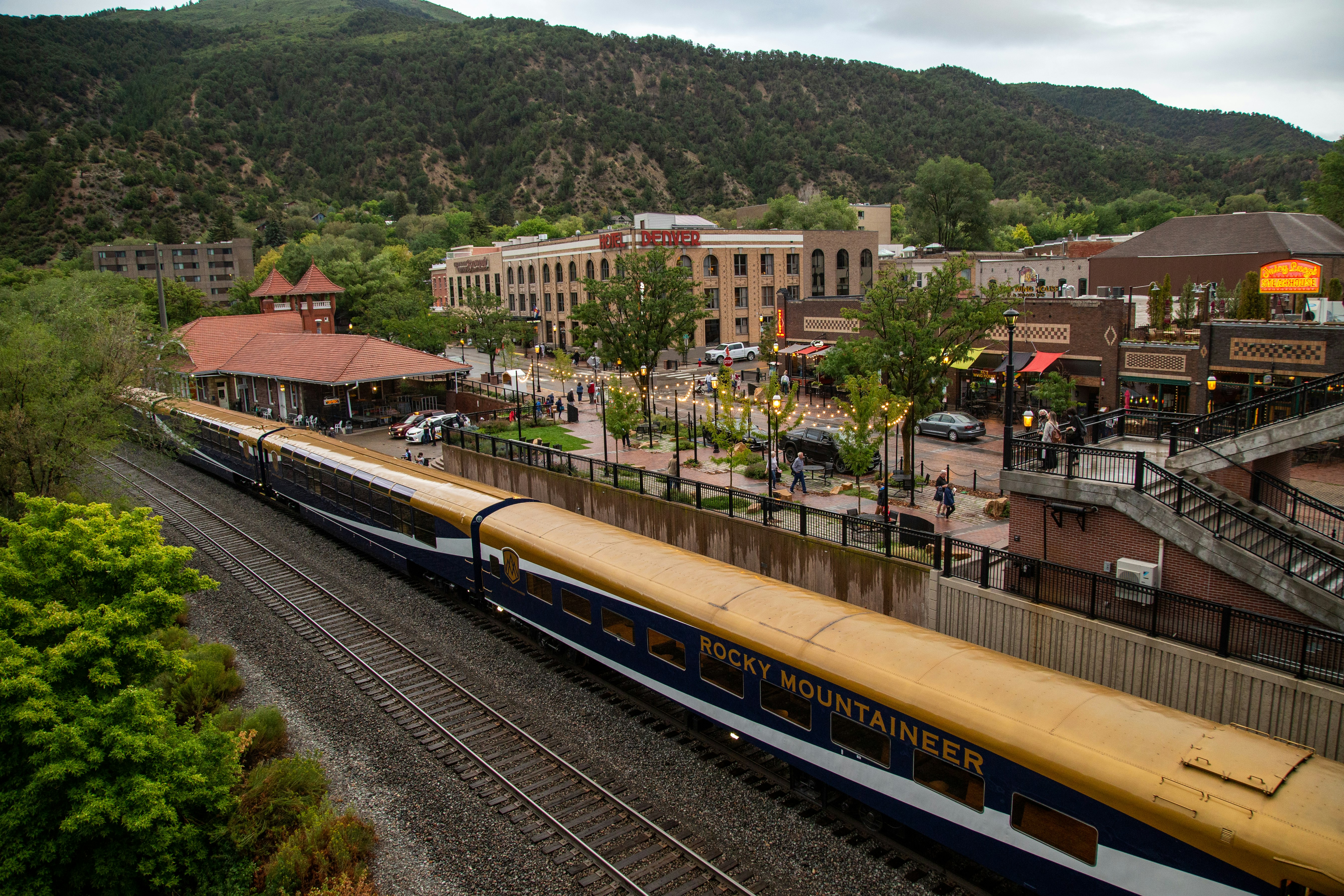 A train stationed in a town surrounded by mountains