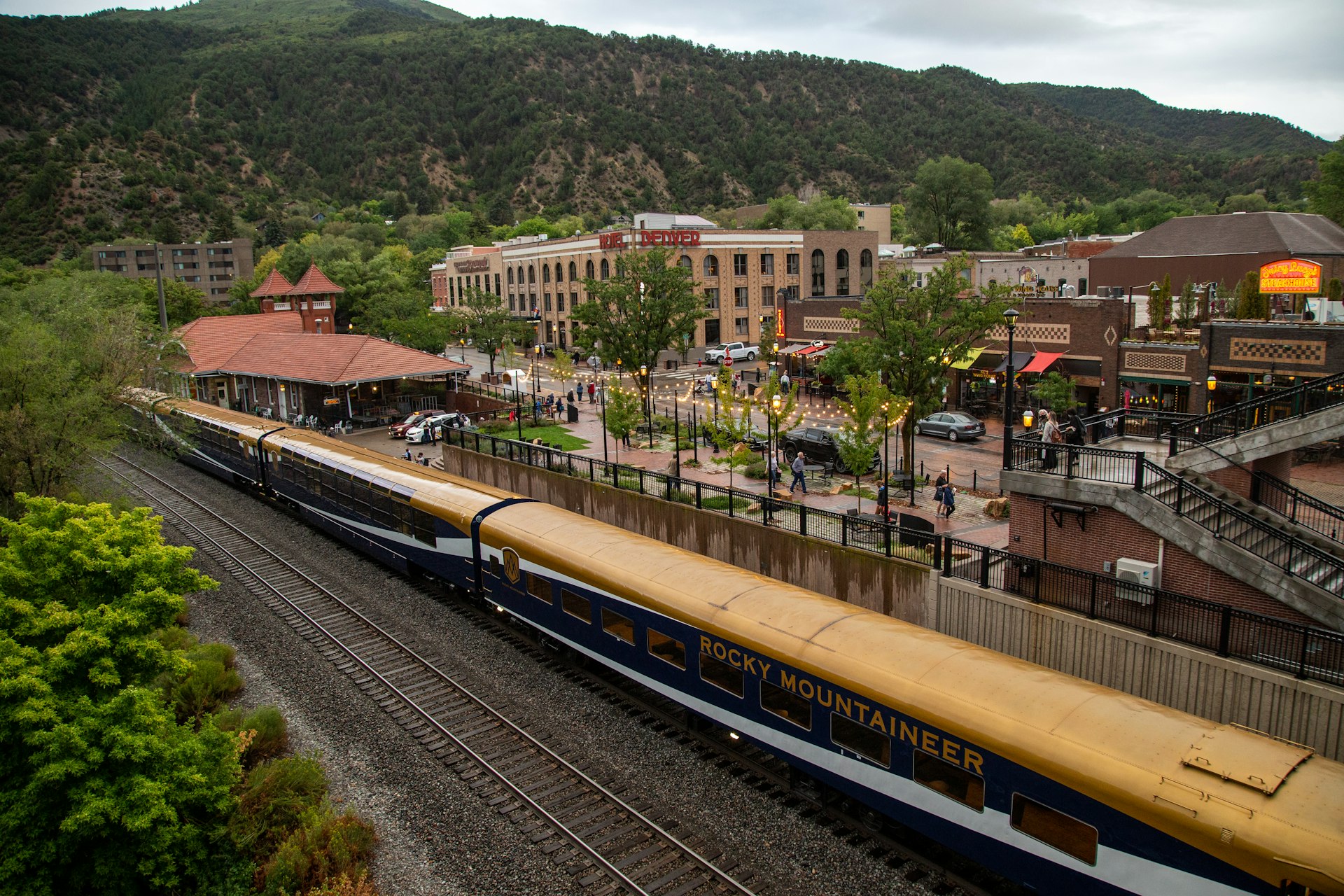 A train stationed in a town surrounded by mountains