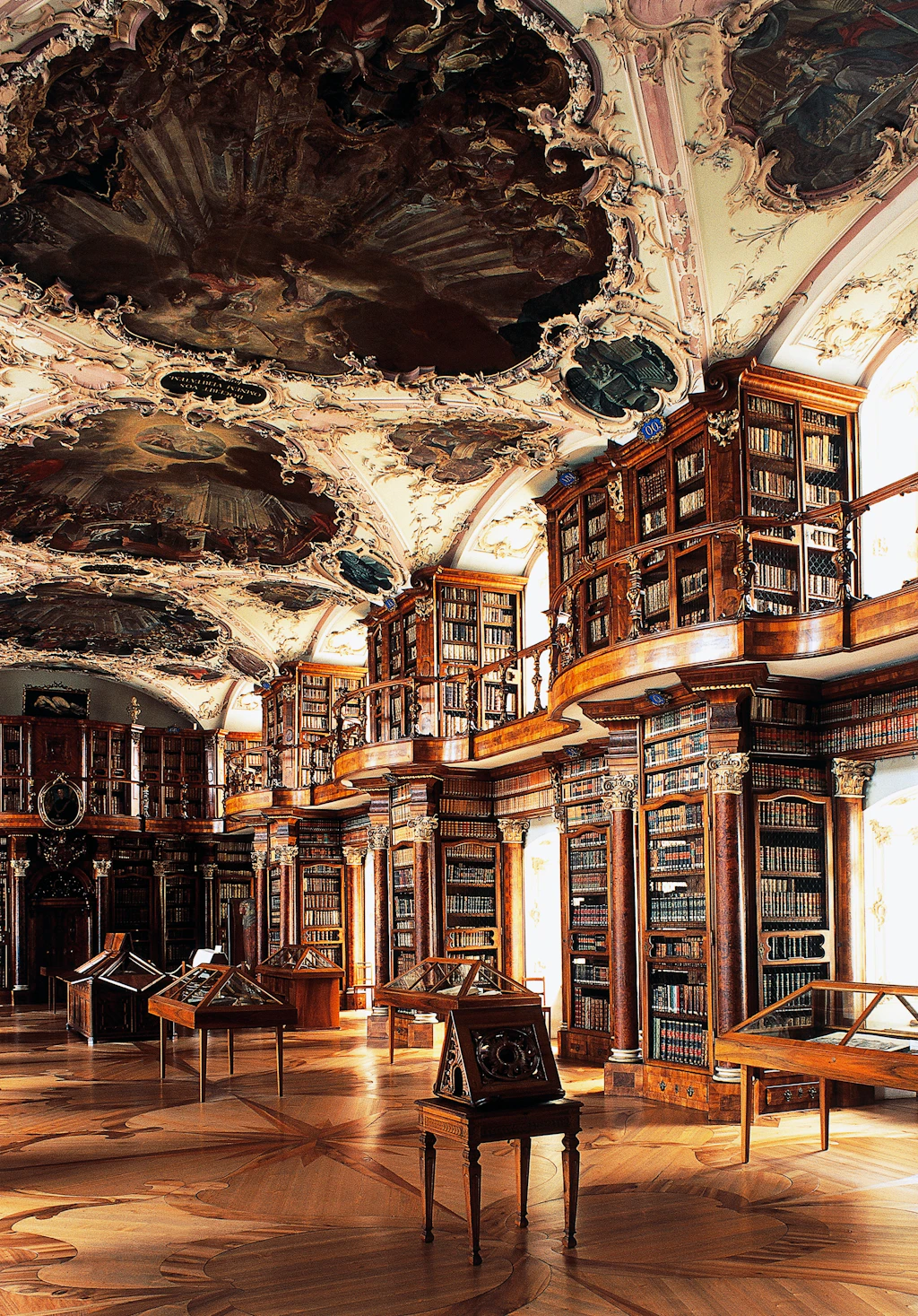 Hall of Stiftsbibliotek A vertical profile of the book shelves in the Stiftsbibliotek, St Gallen. The shelves are filled with books, from floor to ceiling. The ceiling is ornate and covered in murals.