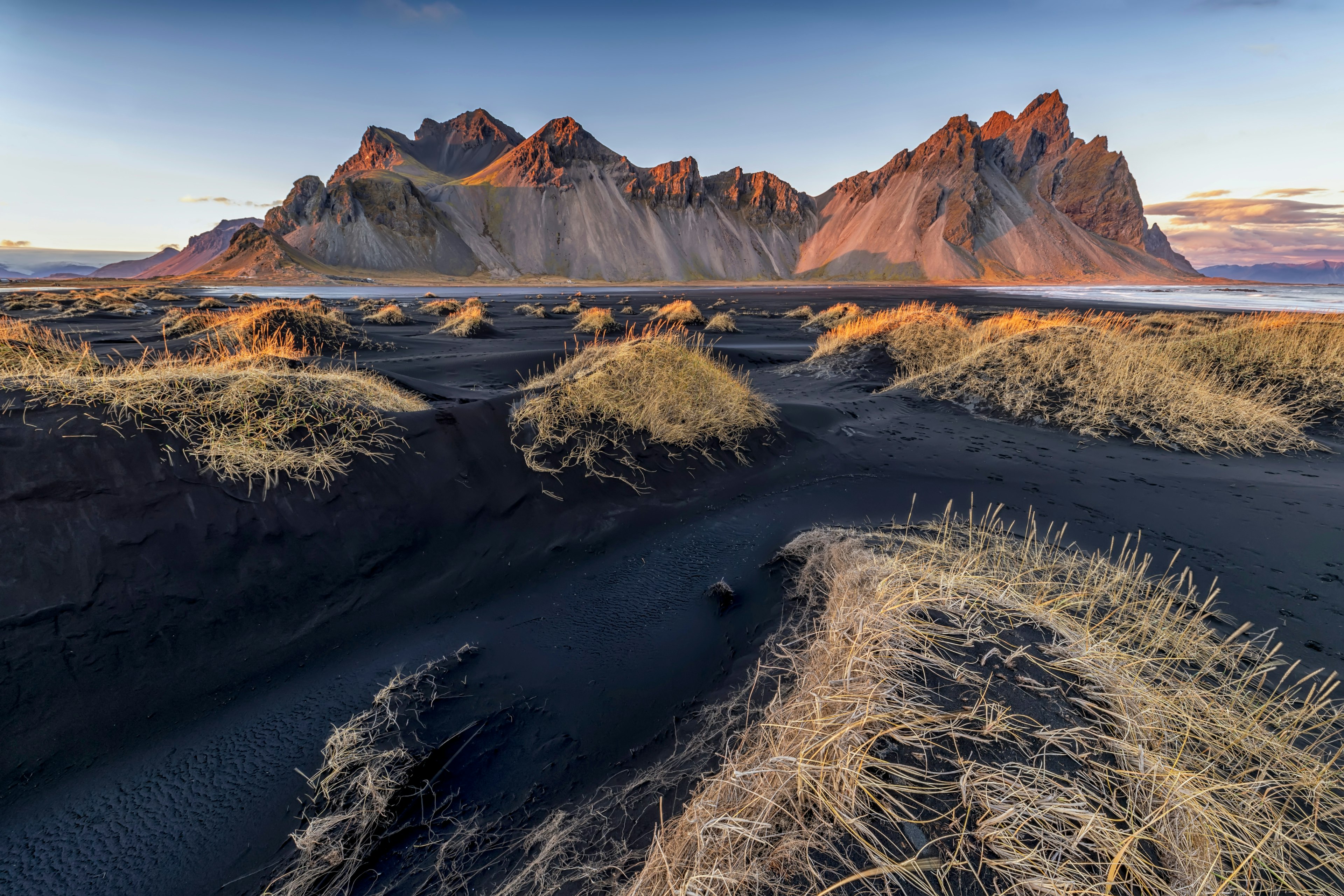 Black sands surround a large mountain peak