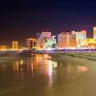 Atlantic City skyline lit up at night, as seen from the beach.
