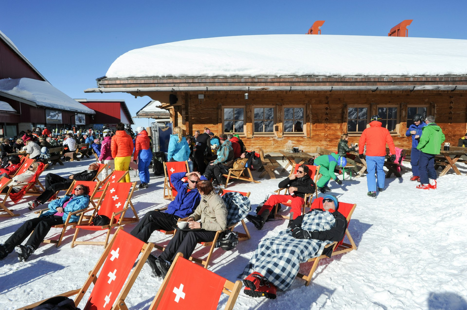 Skiers rest on deckchairs in the snow at the restaurant on mount Titlis