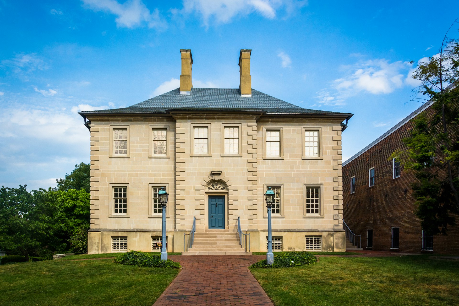 Exterior of the white brick historic Carlyle House in Alexandria, Virginia. 