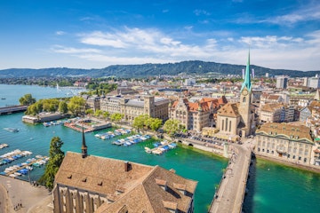 Aerial view of historic Zurich city center with famous Fraumunster Church and river Limmat at Lake Zurich from Grossmunster Church on a sunny day with clouds in summer, Canton of Zurich, Switzerland