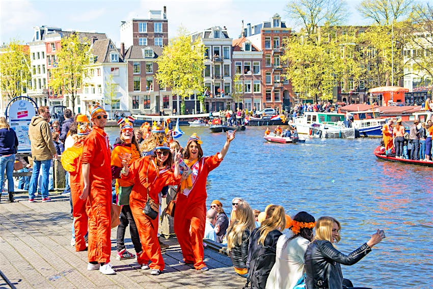 Οι γλεντζέδες, κυρίως ντυμένοι στα πορτοκαλί, κάνουν πάρτι δίπλα σε ένα κανάλι