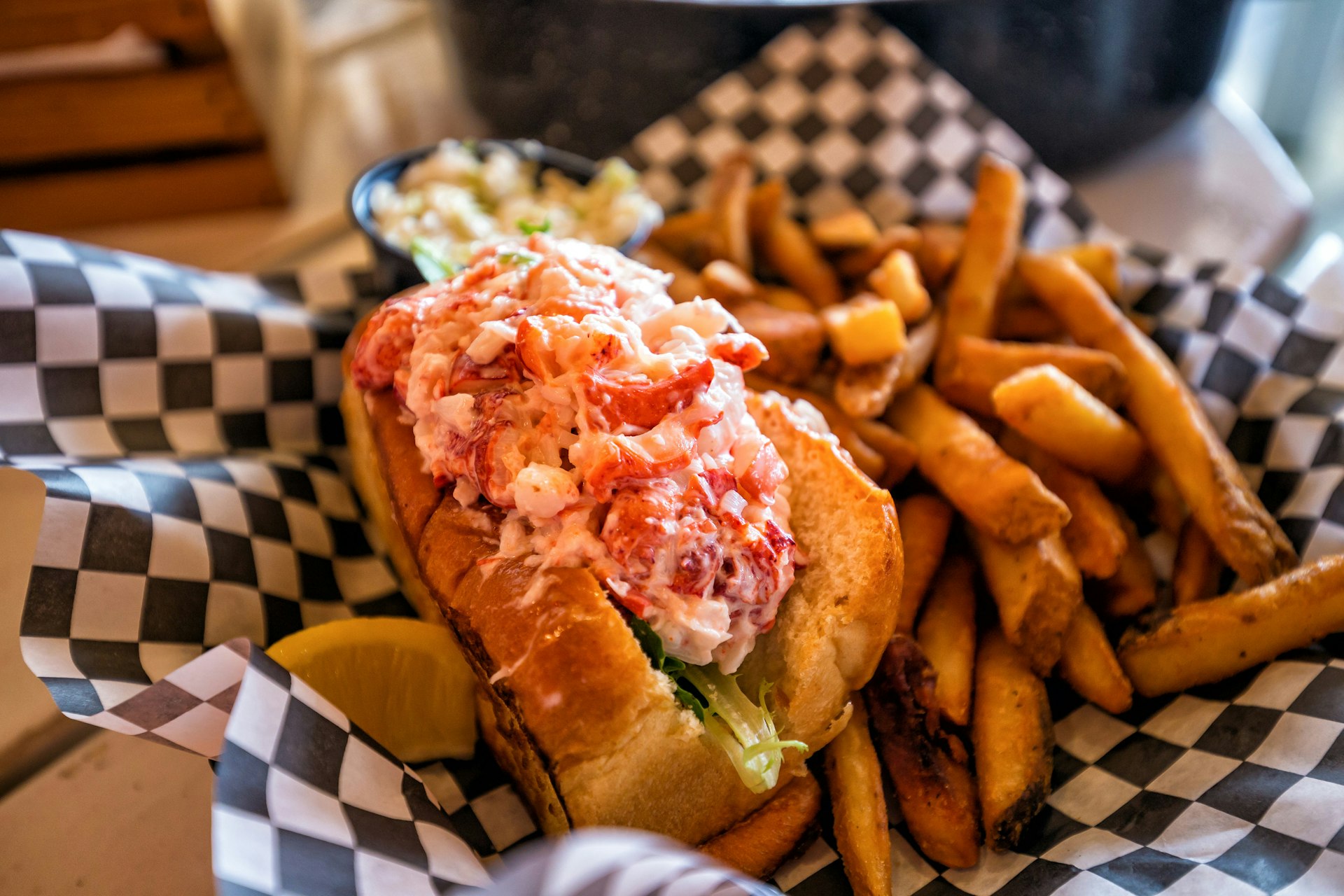 lobster roll served on plate with fries
