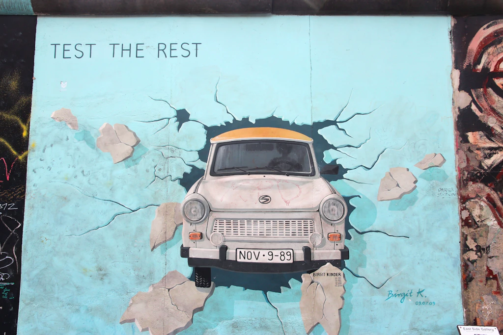 Test The Rest artwork, East Side Gallery The Test The Rest artwork in the East Side Gallery, showing an old-fashioned car bursting through the wall.
