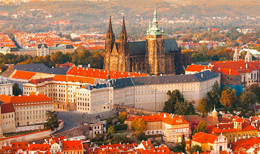shutterstockRF_529523143.jpg Prague Castle complex with gothic St Vitus Cathedral in the evening time illuminated by sunset.