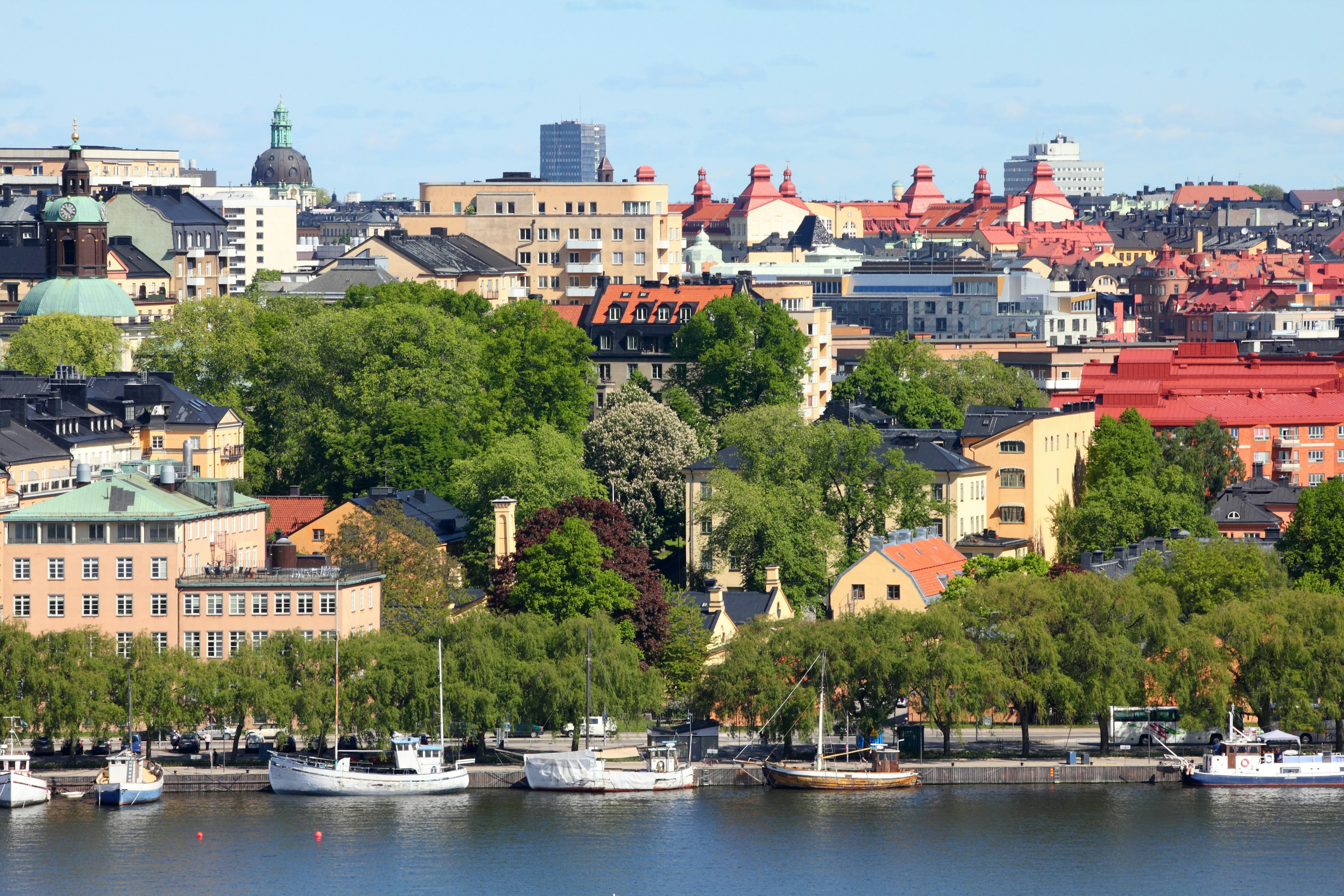 A built-up island viewed across the water with several small boats lining the shore