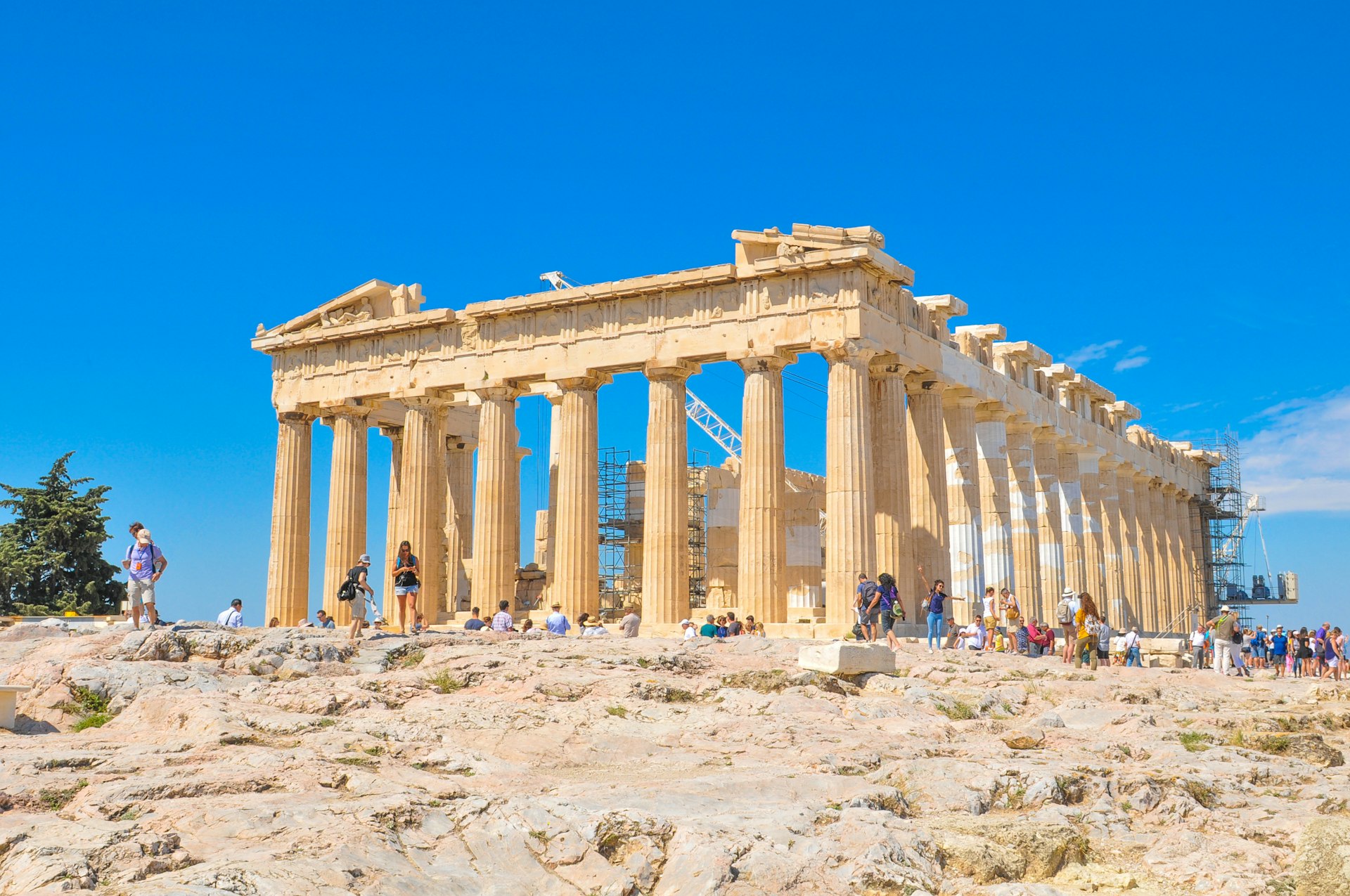 Tourists visit the Parthenon, a former temple dedicated to the goddess Athena in Athens