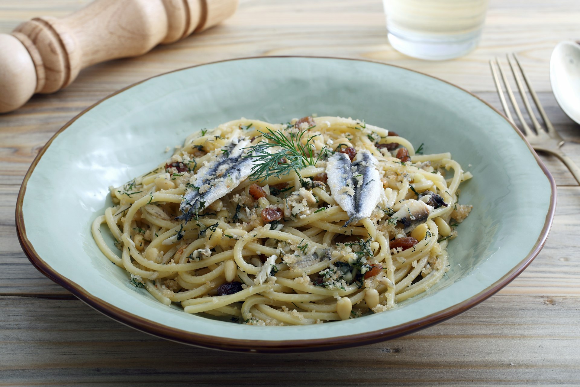 Italian pasta with sardines, served in a blue bowl