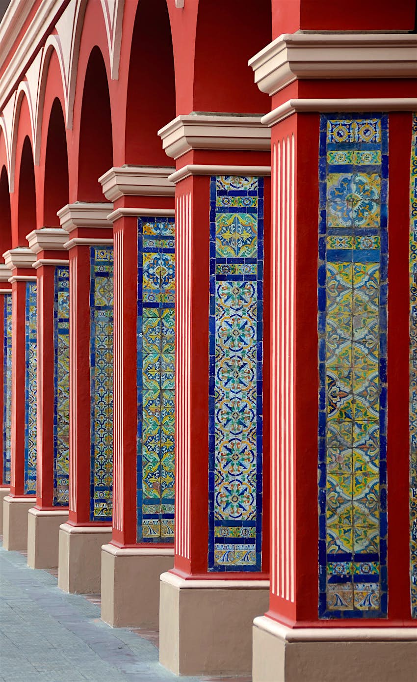 Path of red arch columns with classic colorful tiles in Lima Peru