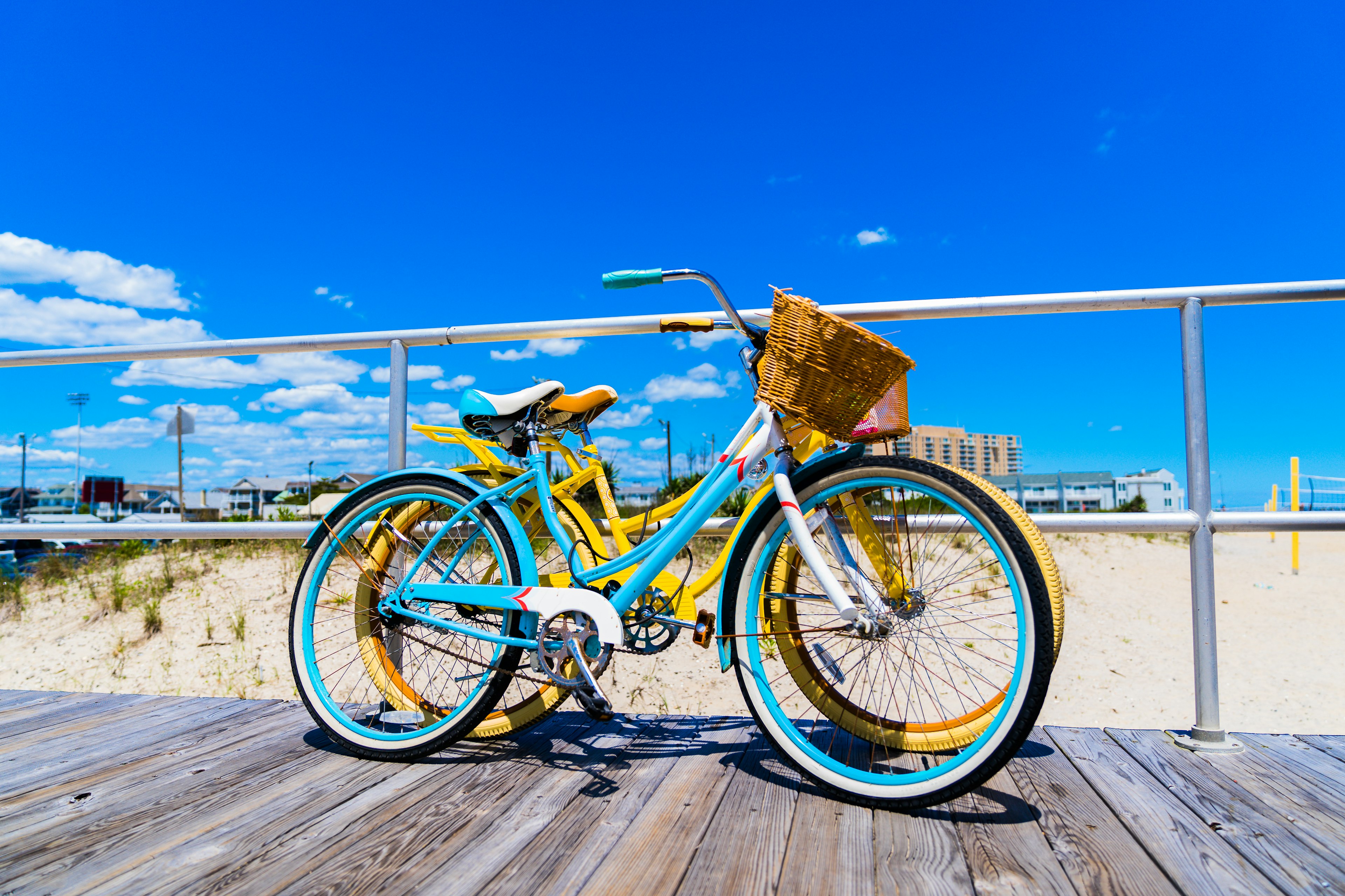 Vintage Style Bicycles Teal and Yellow on Ocean City New Jersey Boardwalk with Beautiful Blue Sky with some Clouds Vivid Colors; Shutterstock ID 1117670270