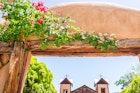 Famous El Santuario de Chimayo sanctuary church in the United States with entrance gate closeup of flowers in summer; Shutterstock ID 1476876161; your: Tasmin Waby; gl: 65050; netsuite: Online Editorial; full: Core Demand