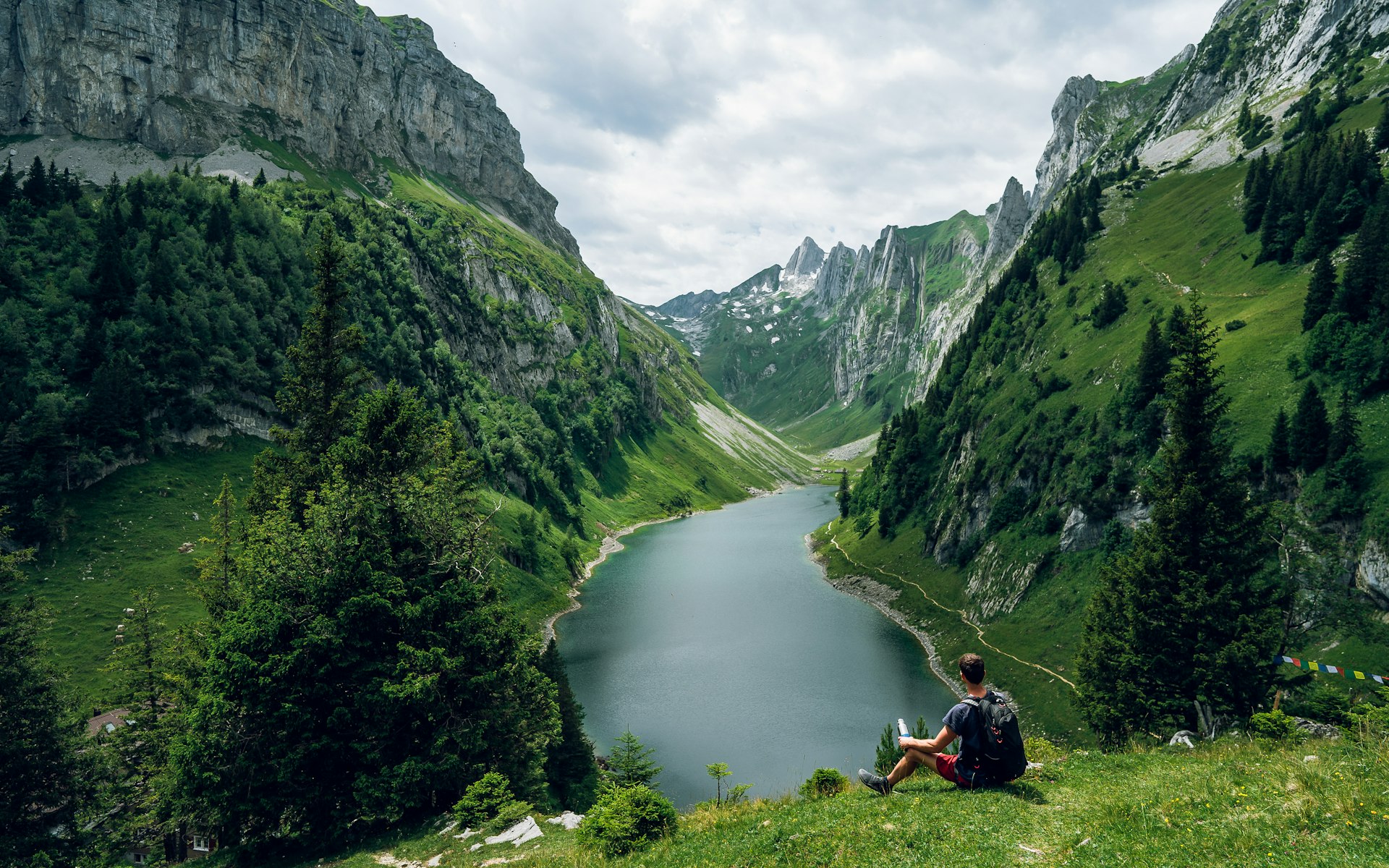 Man resting on a hike overlooking Fälensee lake in Switzerland