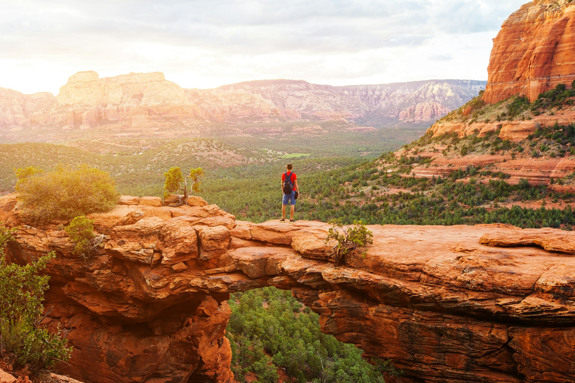 A man standing on the Devil's Bridge rock formation near Sedona