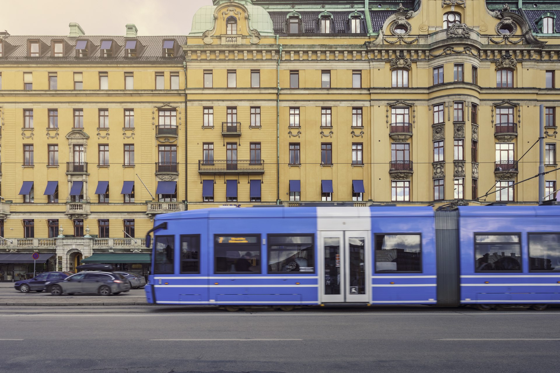 A blue tram passes The Royal Palace in Stockholm
