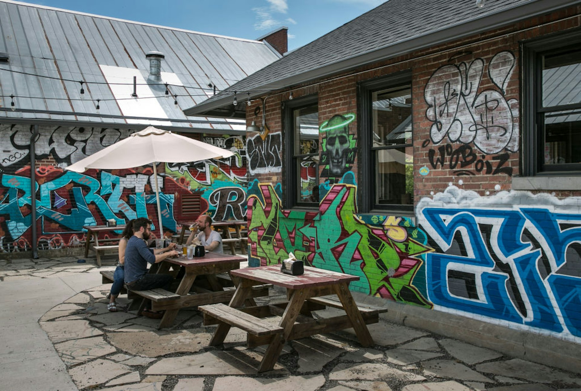 Graffiti on the walls of a popular barbeque spot with outdoor picnic tables