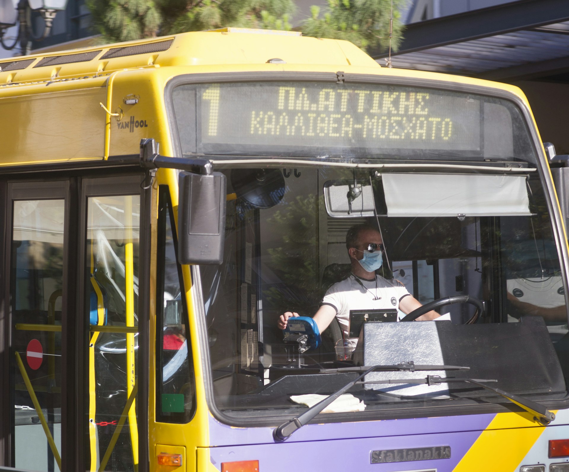 A yellow bus in traffic in Athens