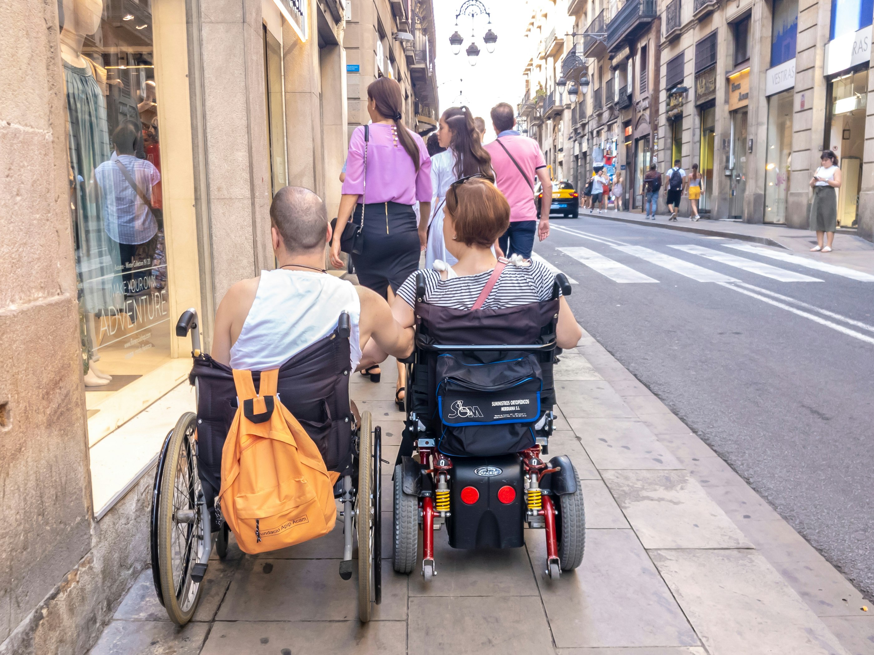 Barcelona wheelchair users traveling together up a Barcelona street