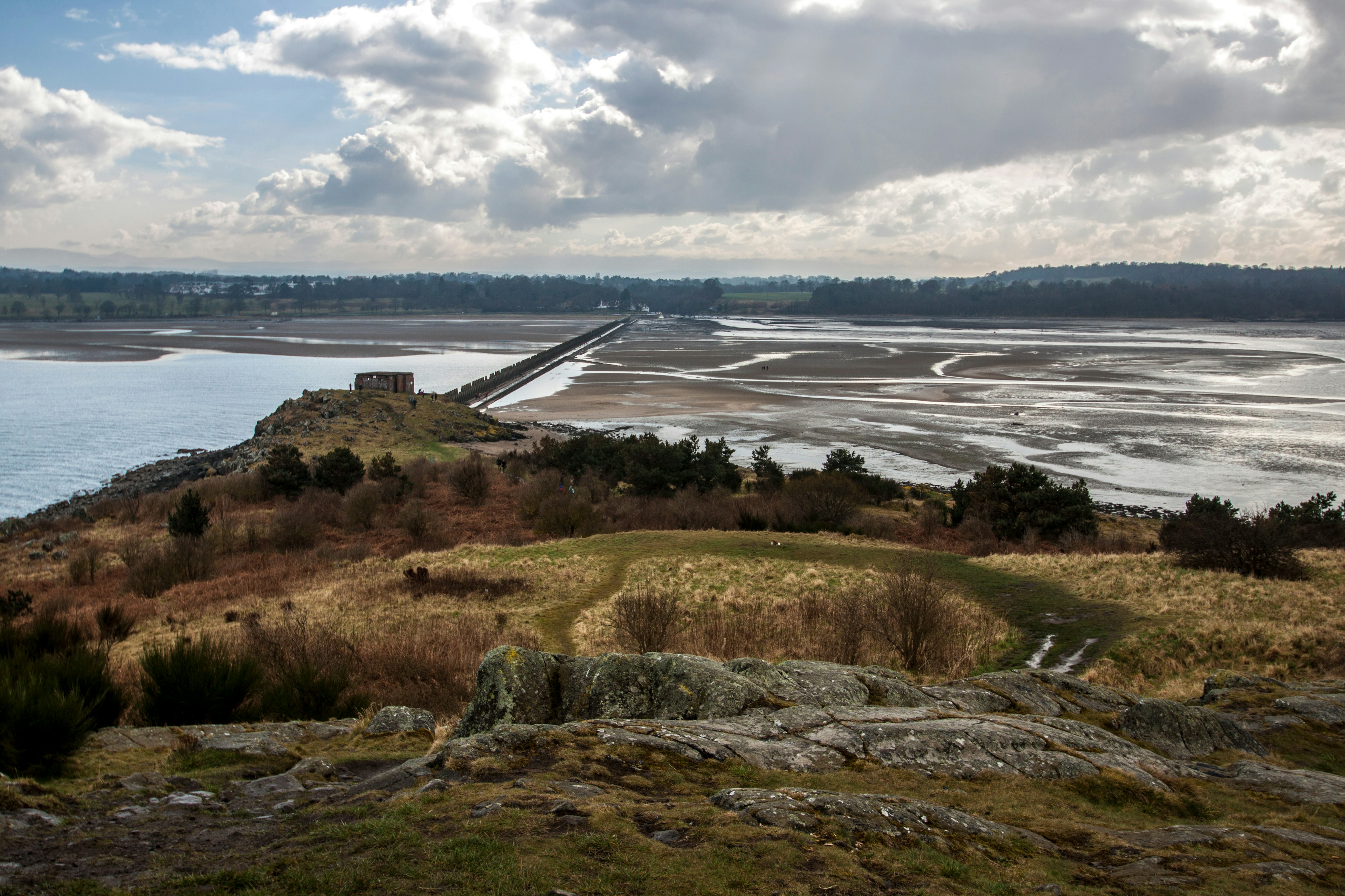 Beautiful landscape with vegetation, sand shore, North Sea and dramatic blue cloudy sky. View from Cramond island, Cramond beach, Edinburgh, Scotland