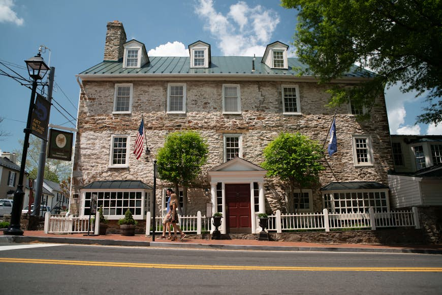 Exterior shot of Middleburg's Red Fox Inn and Tavern, with a man and a woman walking by. 