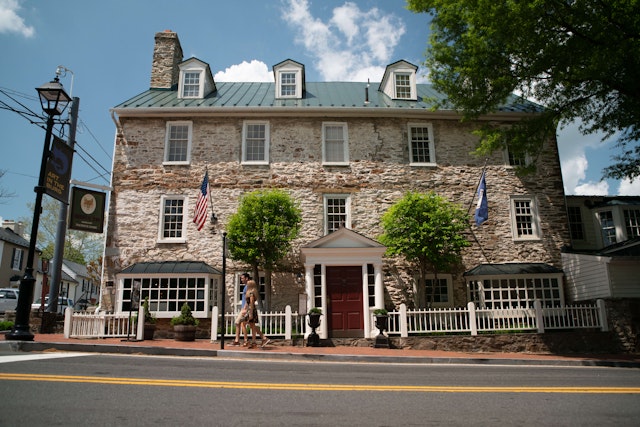 Exterior shot of Middleburg's Red Fox Inn and Tavern, with a man and a woman walking by.