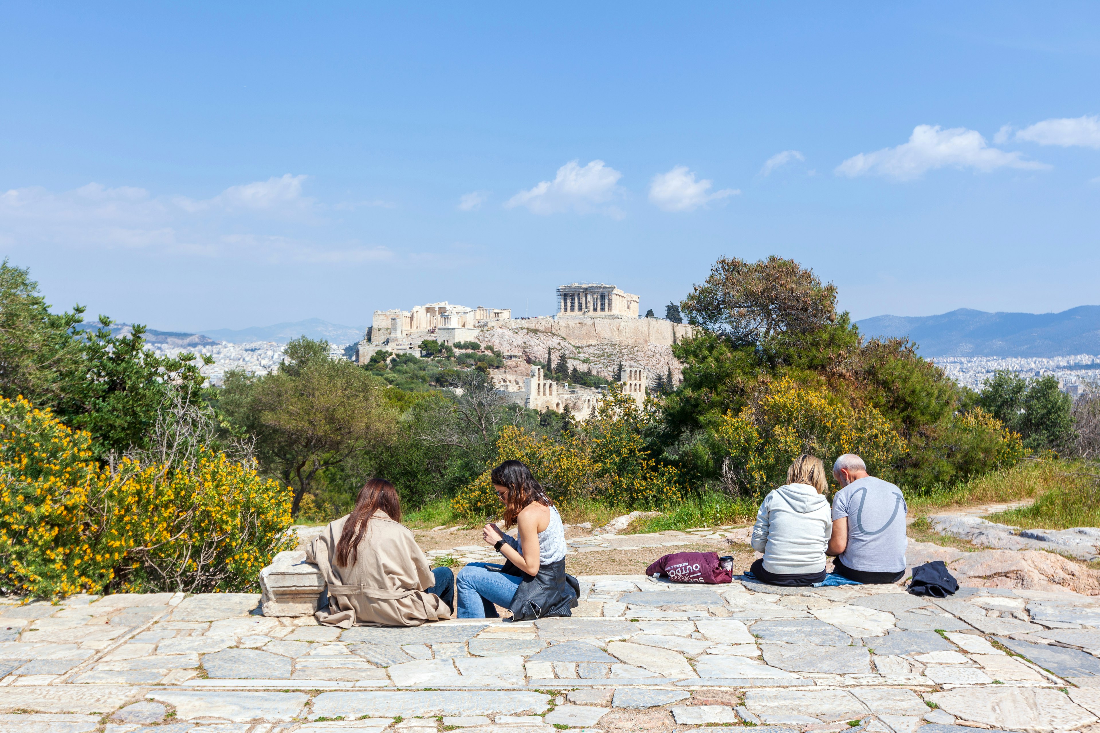 Locals relax in the sun on Filopappou Hill