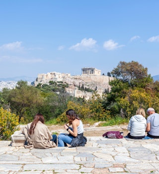 Locals relax in the sun on Filopappou Hill