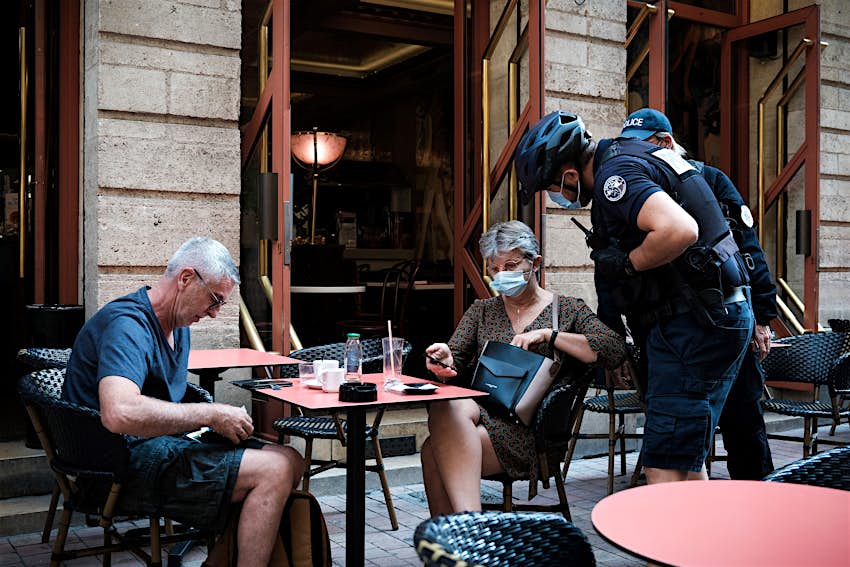 France virus pass A policeman checks the health pass of a customer at a bar in Bordeaux.