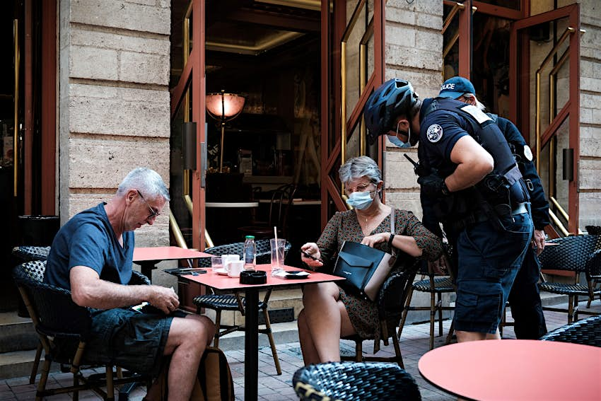 Un policier vérifie le carnet de santé d'un client dans un bar de Bordeaux. 