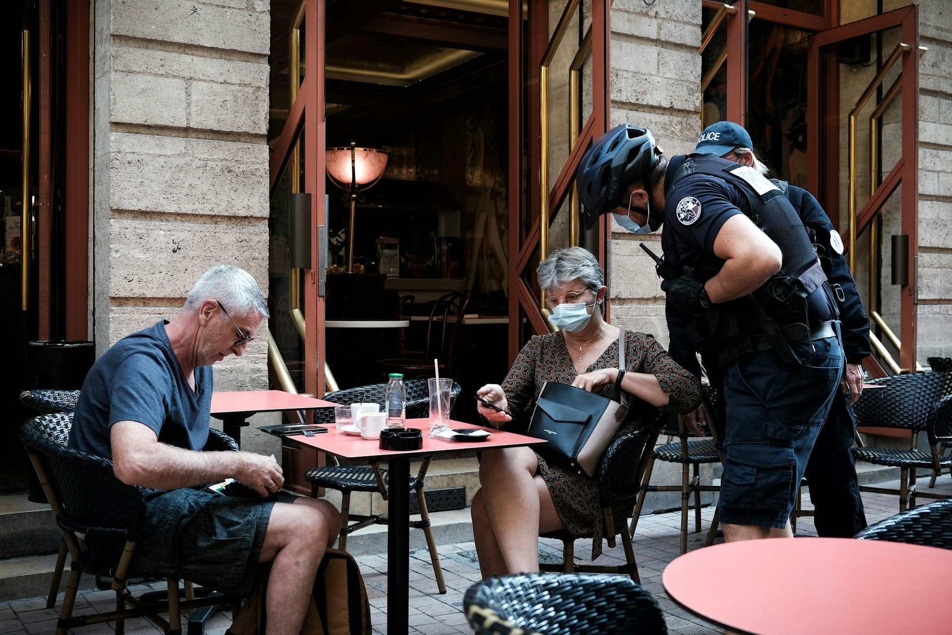 A policeman checks the health pass of a customer at a bar in Bordeaux