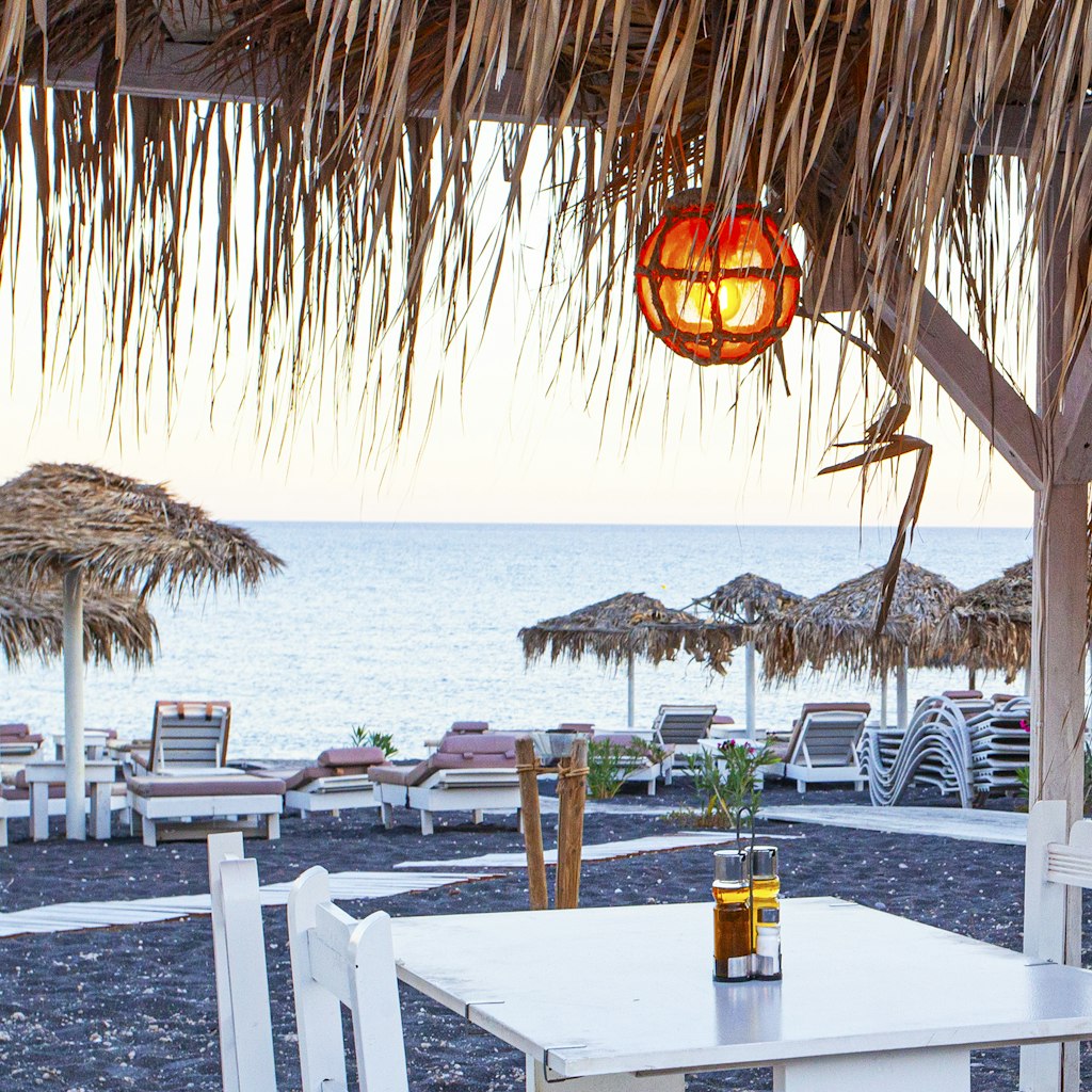 Tables near the Perissa beach in cafe, Santorini island, Greece