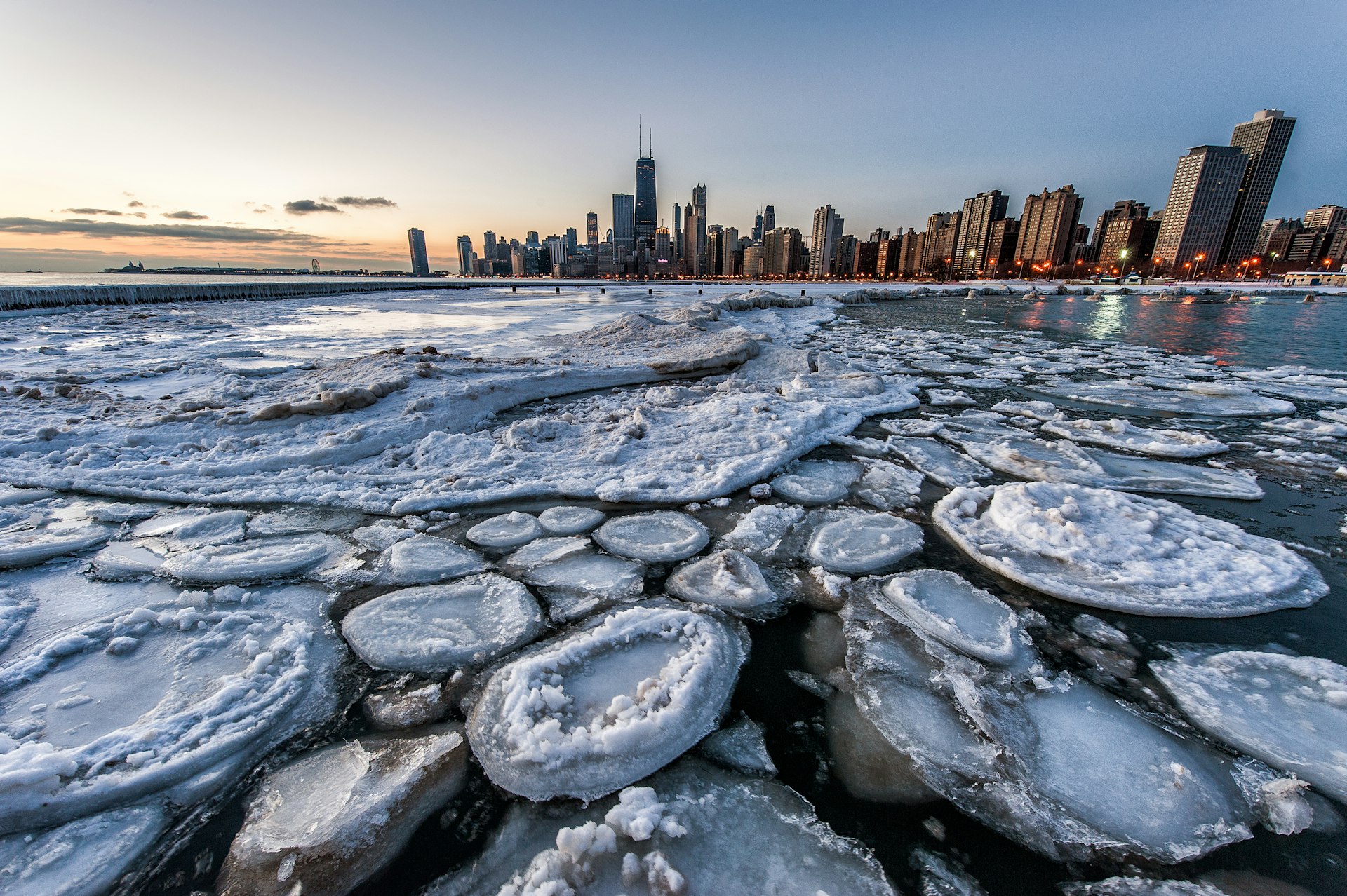 Ice on a lake with a big city skyline with tall skyscrapers in the background