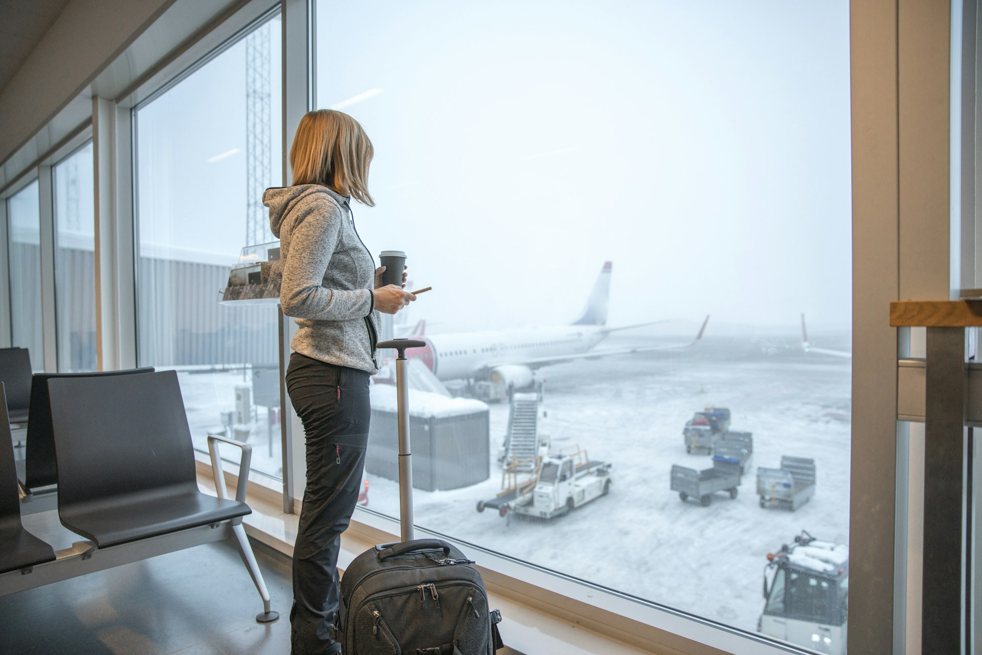 Woman standing close to window at airport