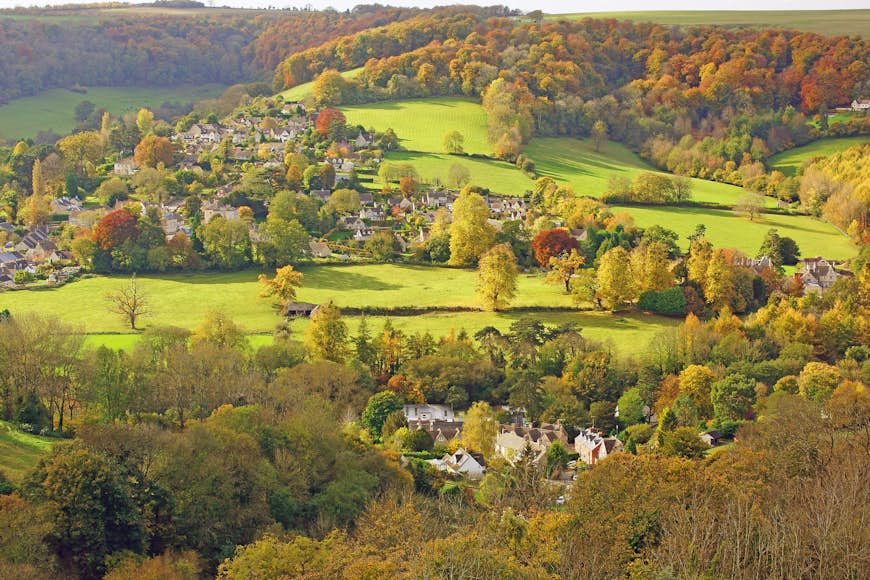 An aerial shot of green fields and fall foliage in Selsley village, Gloucestershire, the Cotswolds, England, United Kingdom