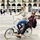 Spain, Barcelona, two happy young women sharing bicycle in the city