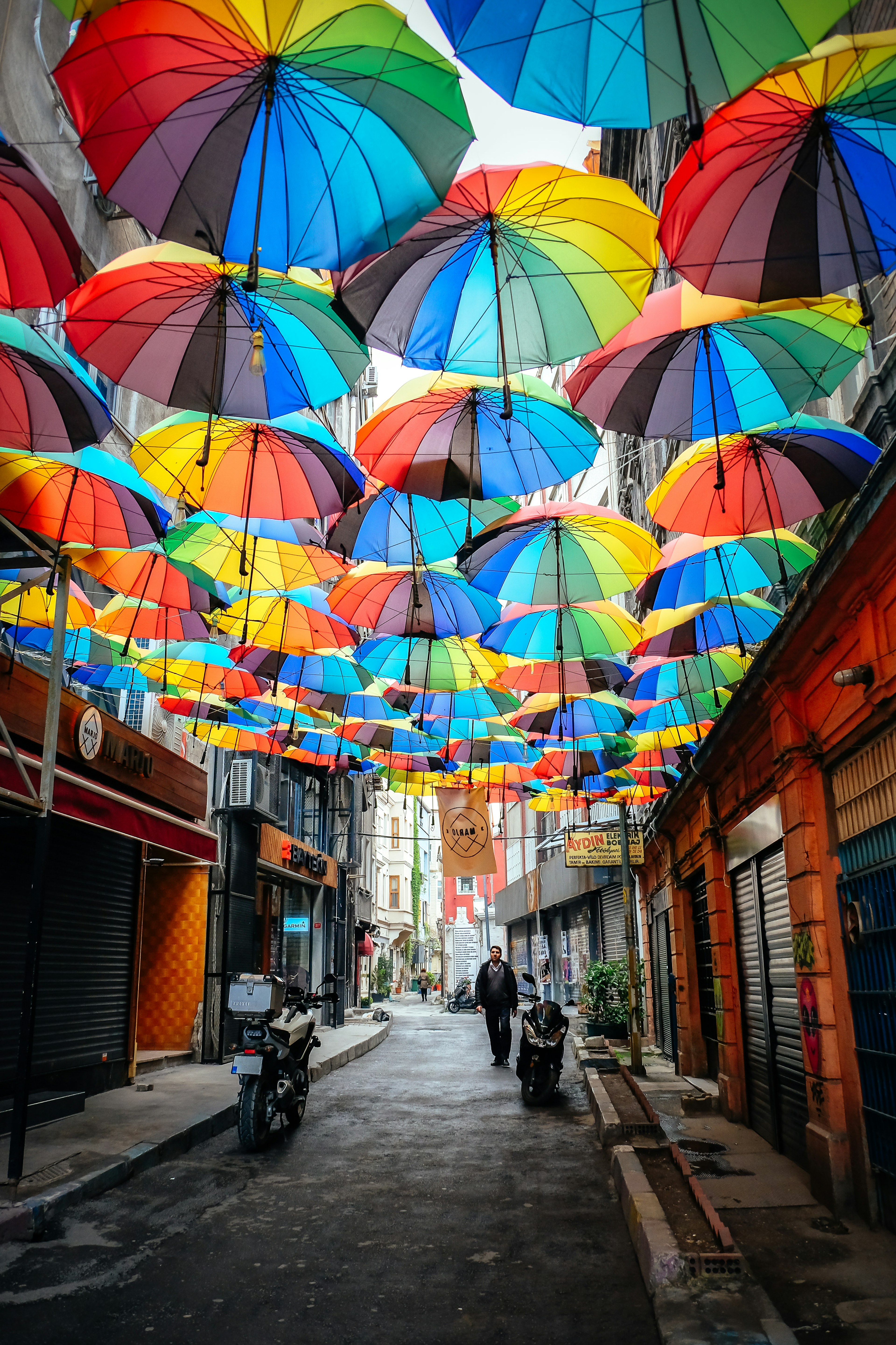 April 24, 2017: Man walking along a street that has been decorated with colourful umbrellas in the hip district of Karakoy.