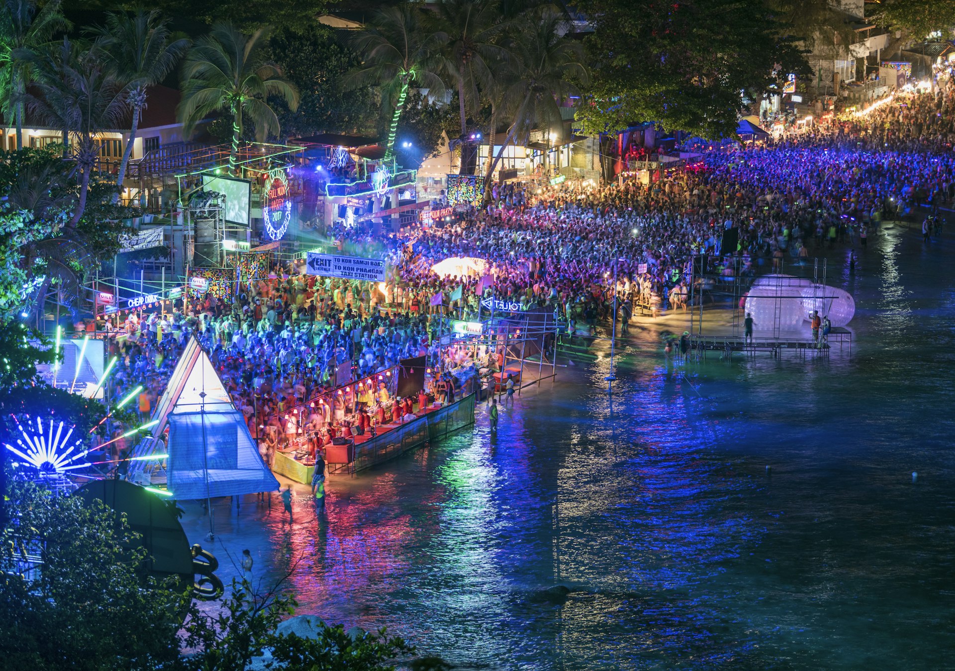 An aerial shot showing a beach crowded with revellers at nighttime